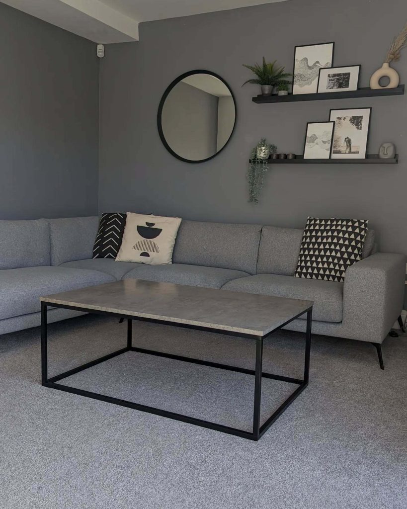 Moody grey walls with a sleek sectional and bold graphic accents.