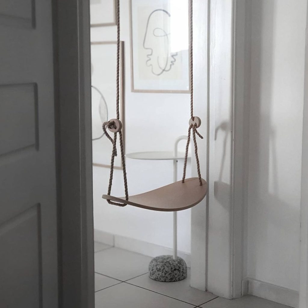 Minimalist wooden swing in a quiet and modern nook.
