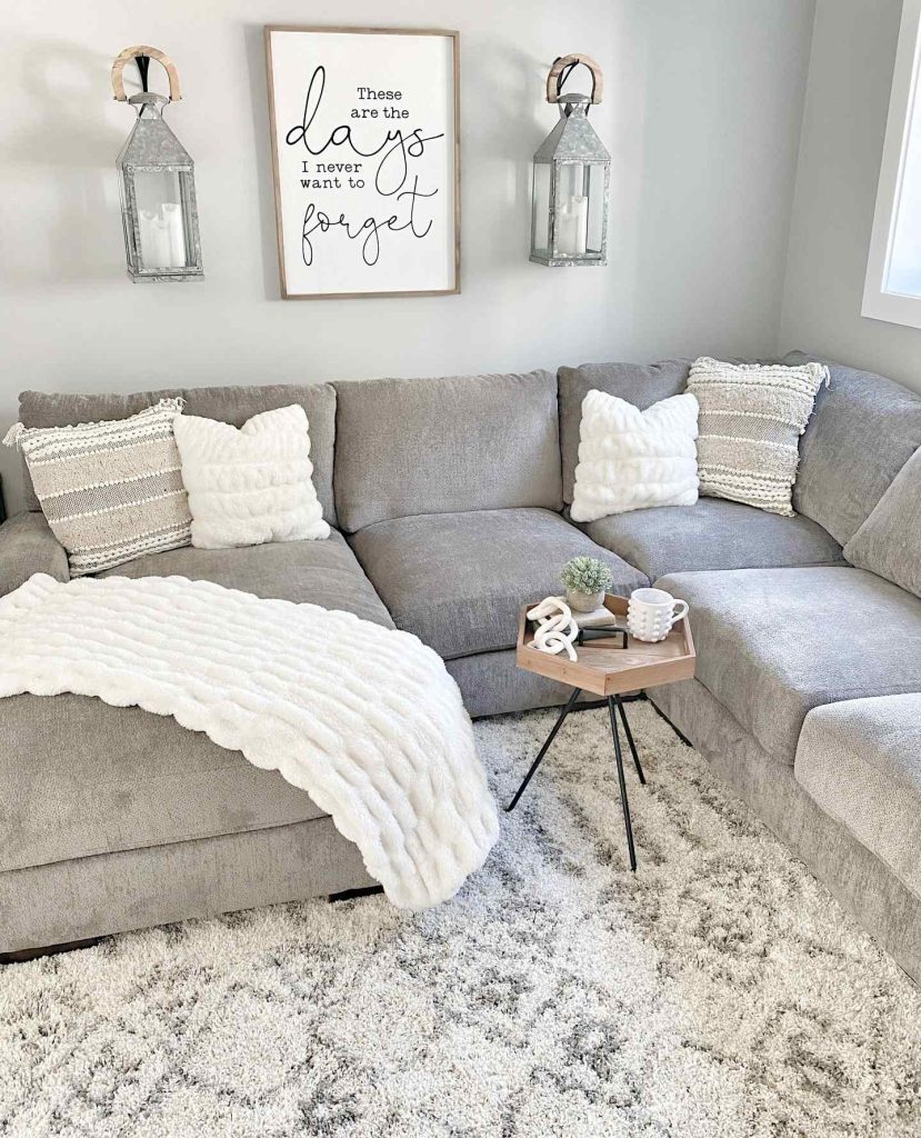 Plush grey sectional with layered pillows and rustic lanterns.
