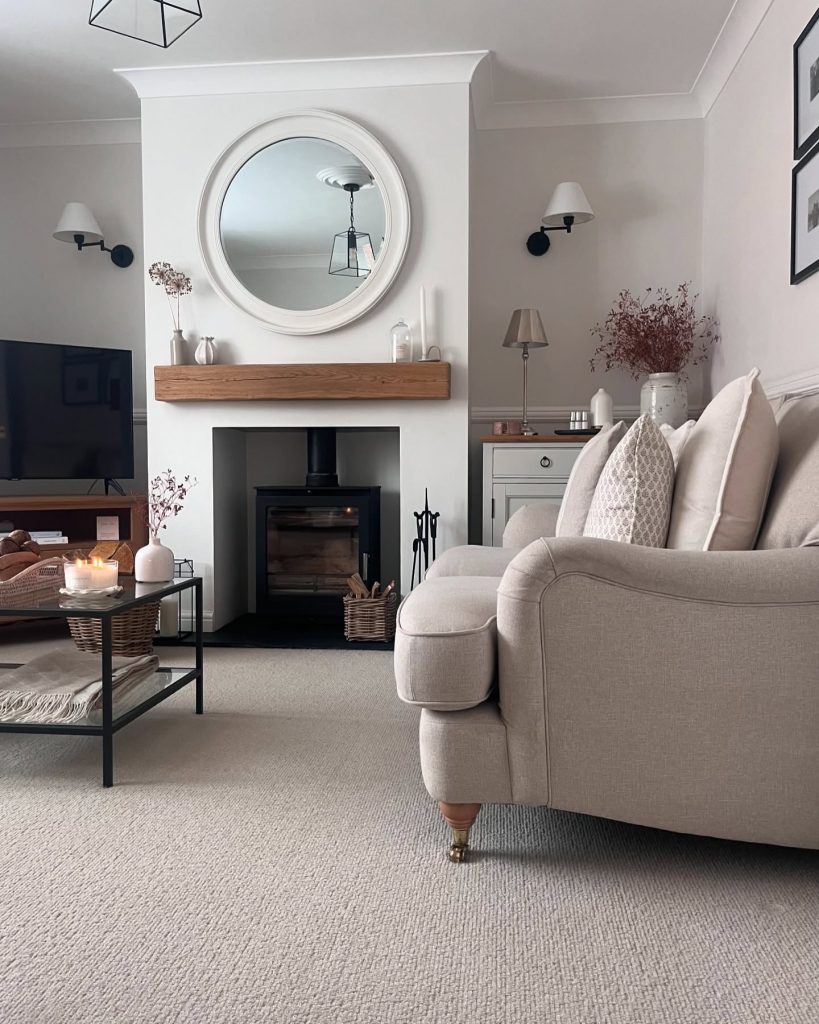 Modern white fireplace with a wooden mantel and neutral decor.
