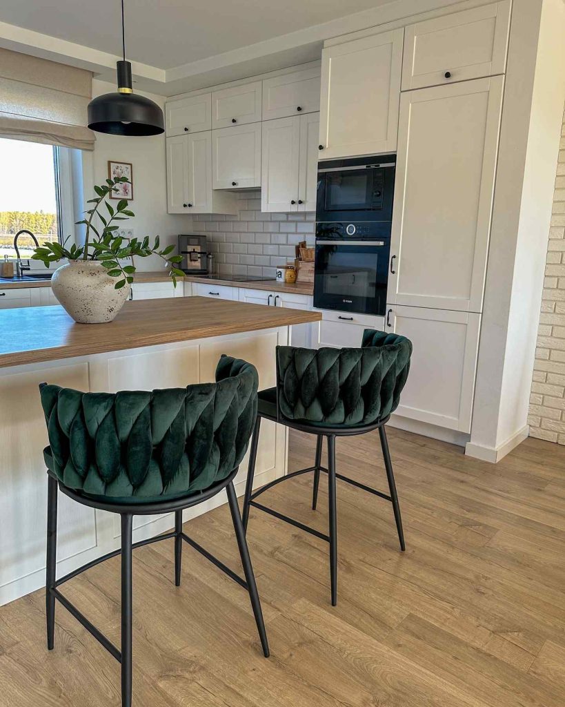 Bright kitchen with velvet bar stools and white cabinetry.
