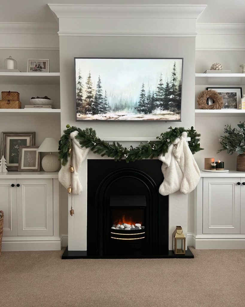 Classic black arched fireplace with green garland and white stockings.
