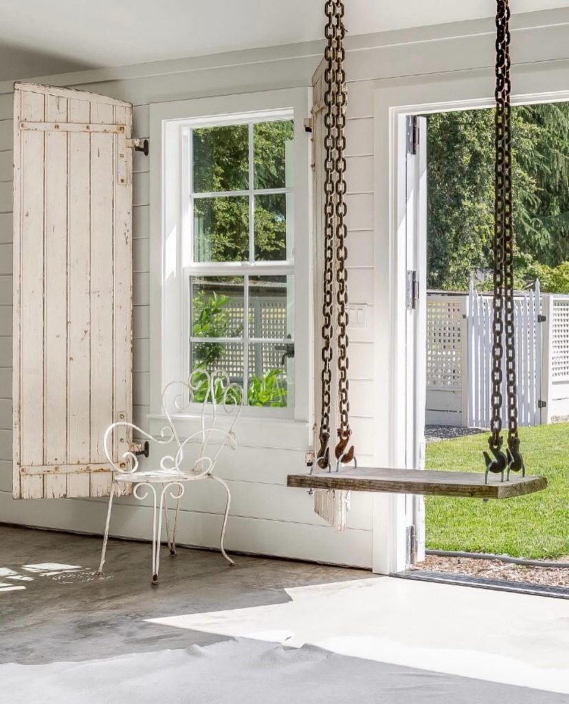 Industrial-style swing with metal chains and a wooden seat.
