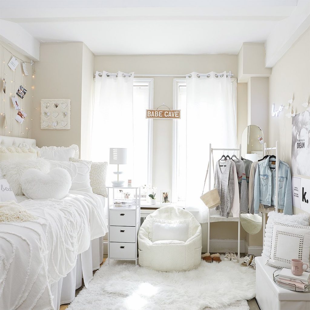 Minimalist white dorm featuring a cozy bean bag chair, fairy lights, and elegant decor.
