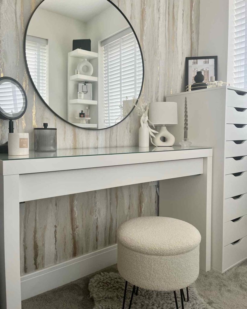 White vanity with marble-inspired backdrop and textured decor.
