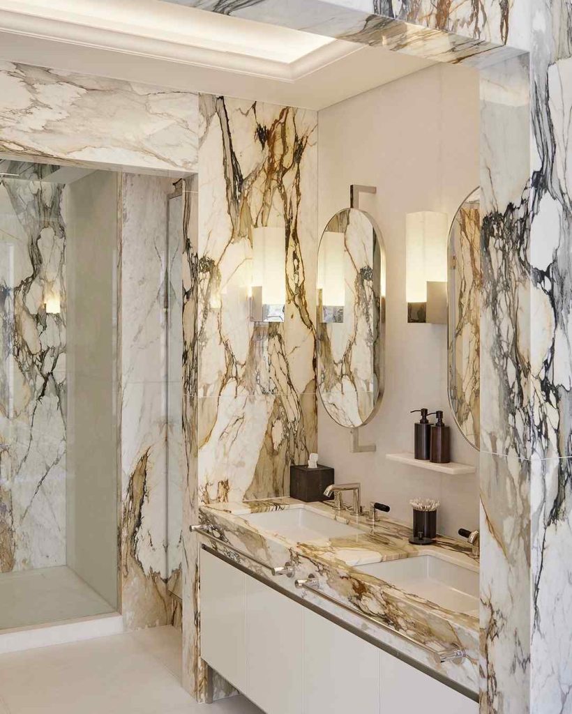 Golden-veined marble bathroom with sleek double sinks and lighting.