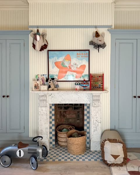 Children's playroom fireplace with marble mantel and whimsical animal decor.
