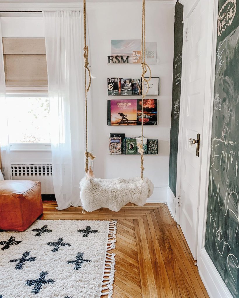 Fluffy swing in a cozy reading nook with chalkboard walls.
