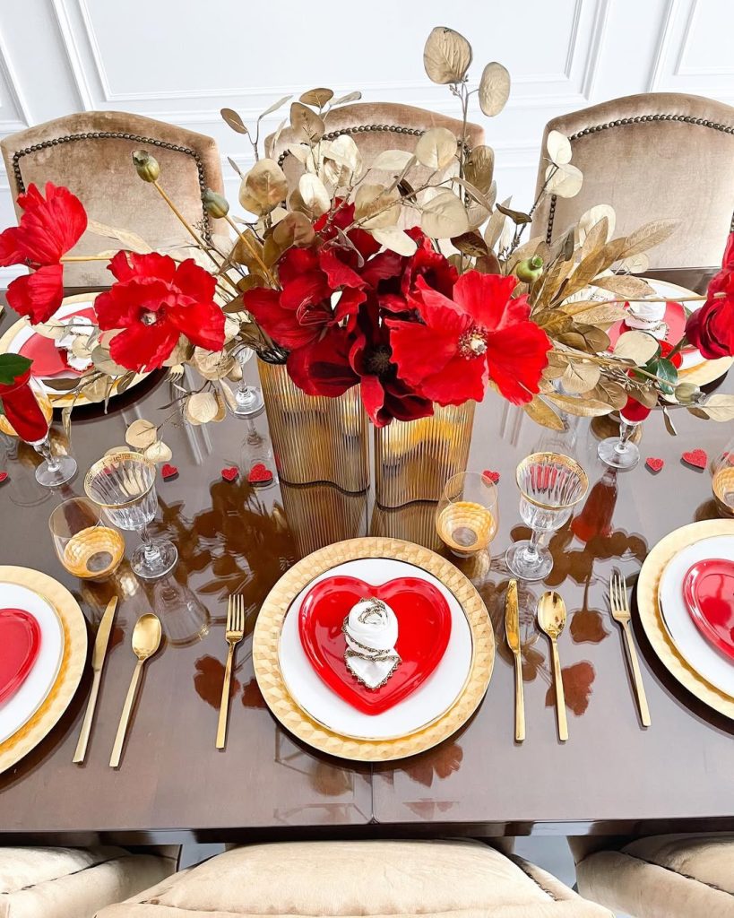 Elegant romantic tablescape with bold red flowers and golden accents.
