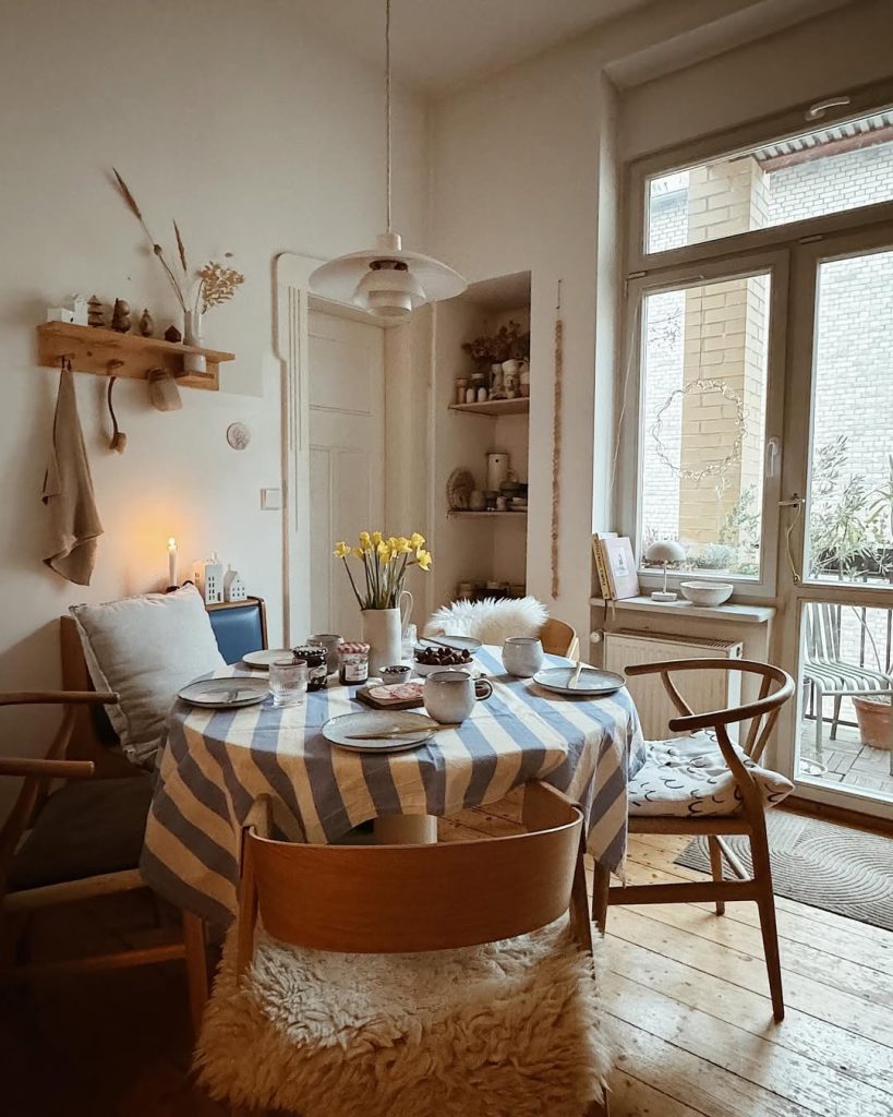 Charming small cozy kitchen with warm lighting, rustic decor, and a vintage dining nook.
