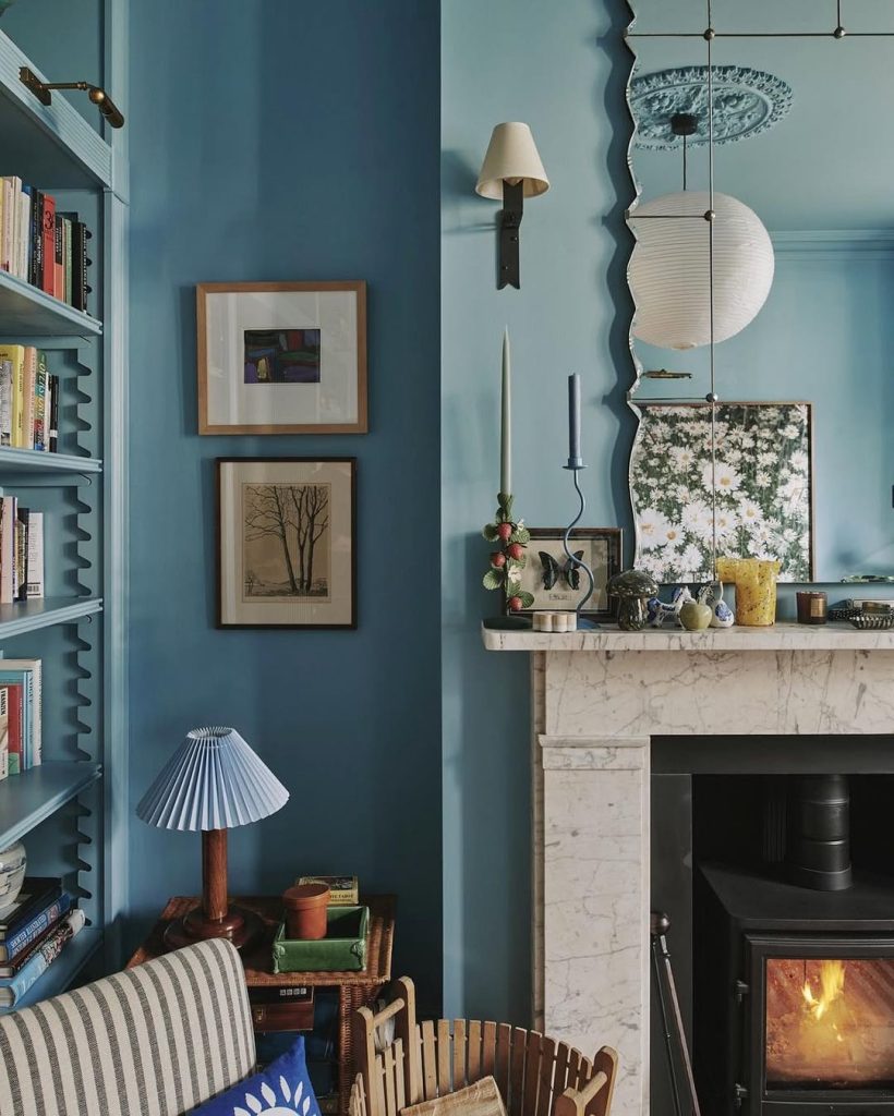 Soft blue walls and a classic white fireplace create a serene and airy living room.