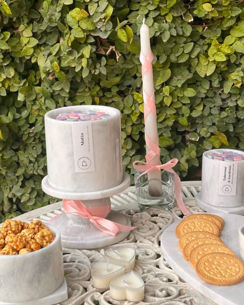 Minimal romantic table decoration with marble accents and heart-shaped candles.
