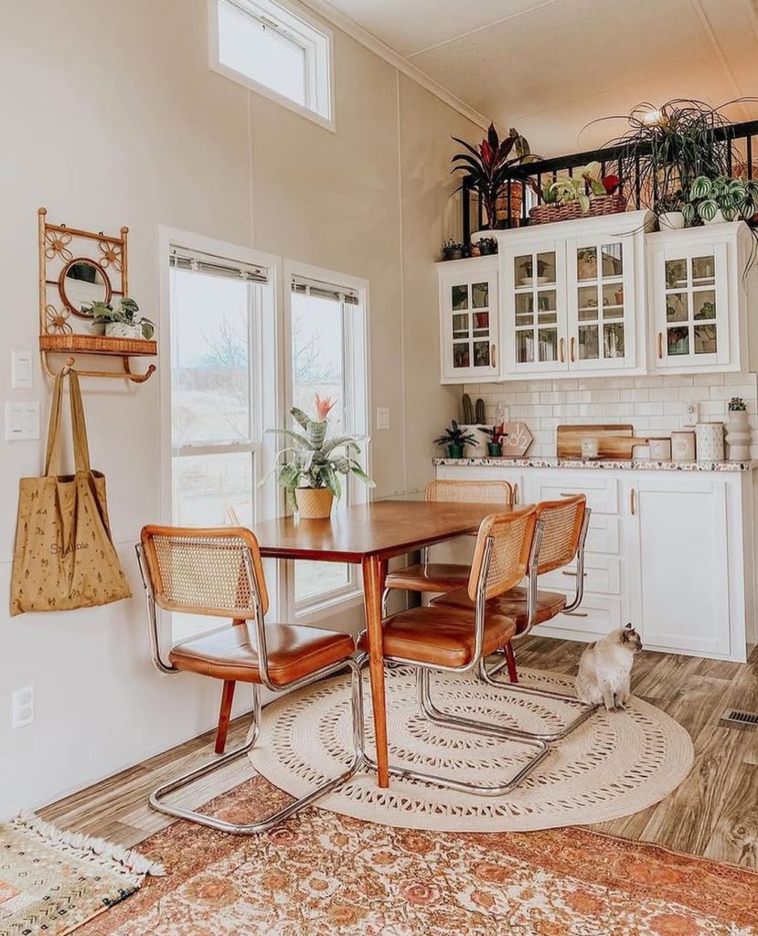 Retro-inspired boho kitchen with cane chairs and vintage decor.
