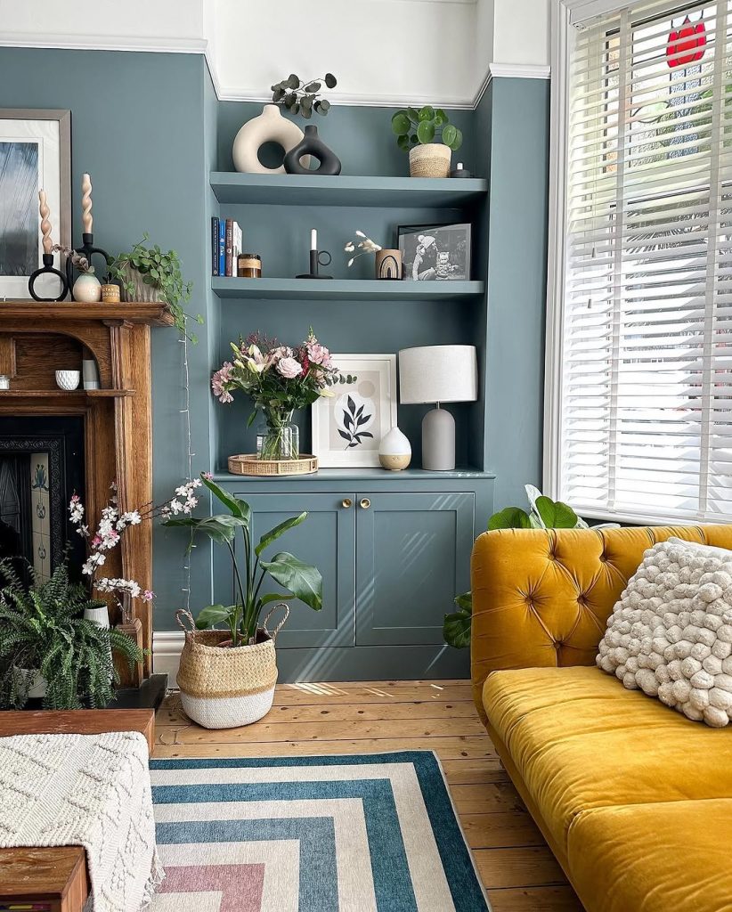 Charming blue walls with pastel decor and a curved mirror above a white fireplace