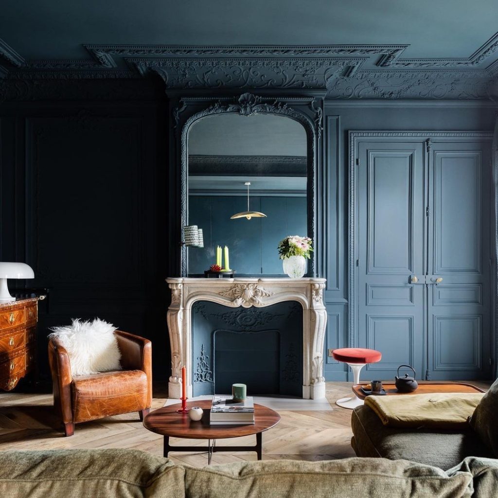 Navy accent wall paired with cozy blue cushions and neutral tones for balance.