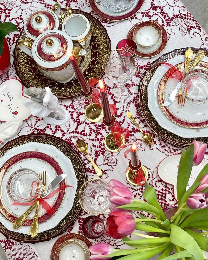 Regal romantic table setting with burgundy and gold china and tulip centerpiece.
