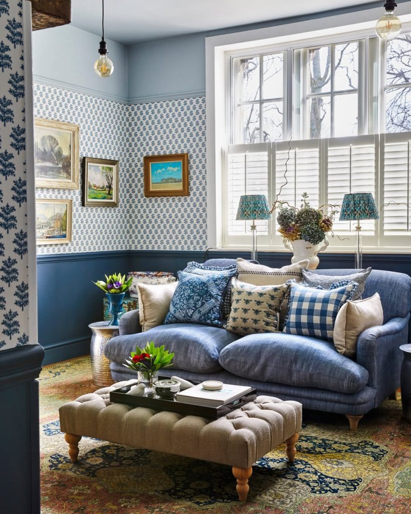 Velvety blue sofa blends beautifully with matching walls in a warm, inviting space.