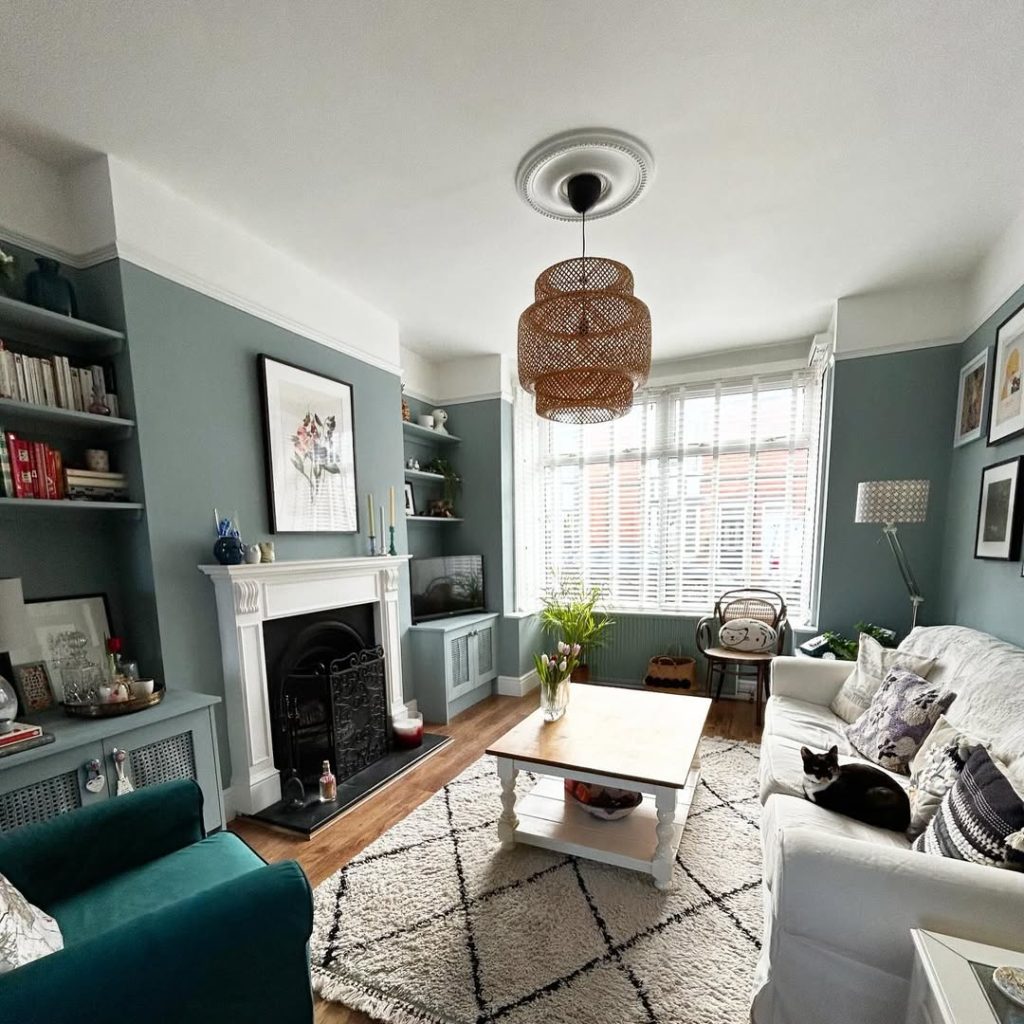 Bold patterned wallpaper and navy sofas with yellow accents in a luxe living room