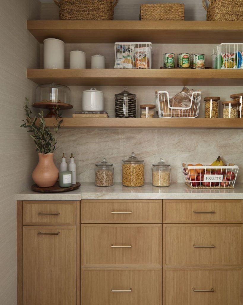 Warm and inviting pantry with marble countertops and stylish storage baskets.
