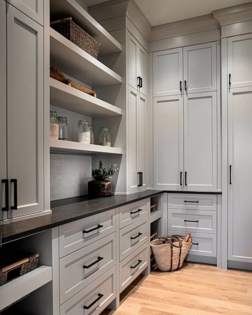 Minimalist kitchen pantry with open shelves and woven storage baskets.
