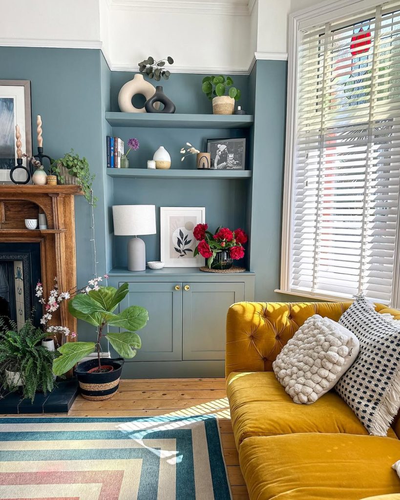 Soft blue walls paired with a mustard sofa and curated shelves for a fresh living space.