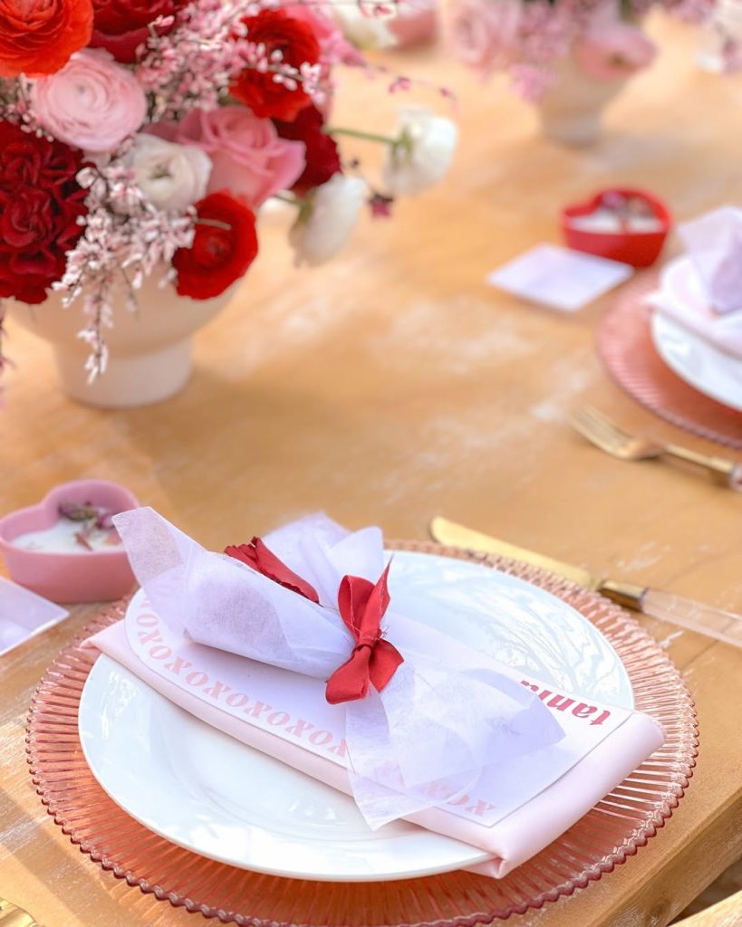 Delicate romantic tablescape with blush-toned chargers and lush floral centerpiece.
