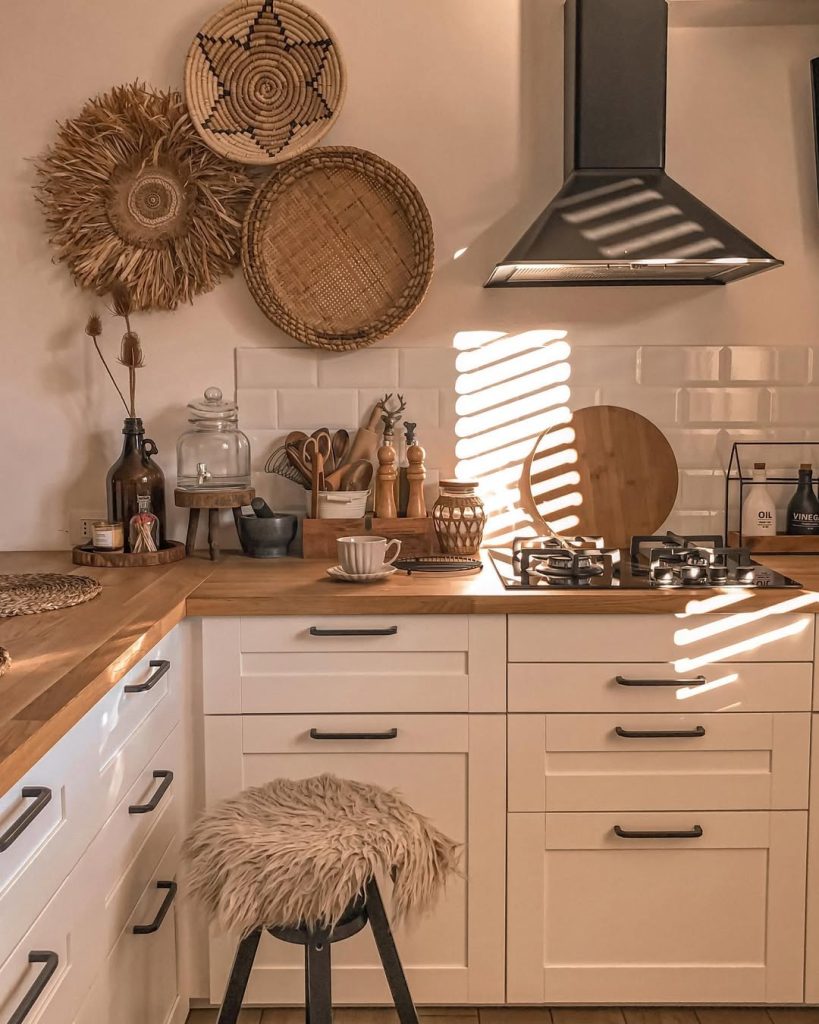 Golden hour bohemian kitchen with woven wall art and soft textures.
