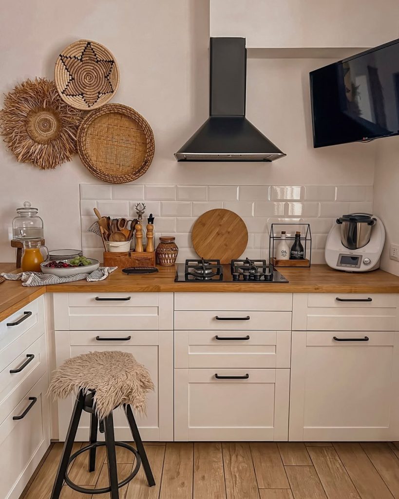 Scenic cozy kitchen with a large window, patterned tile flooring, and rustic decor.
