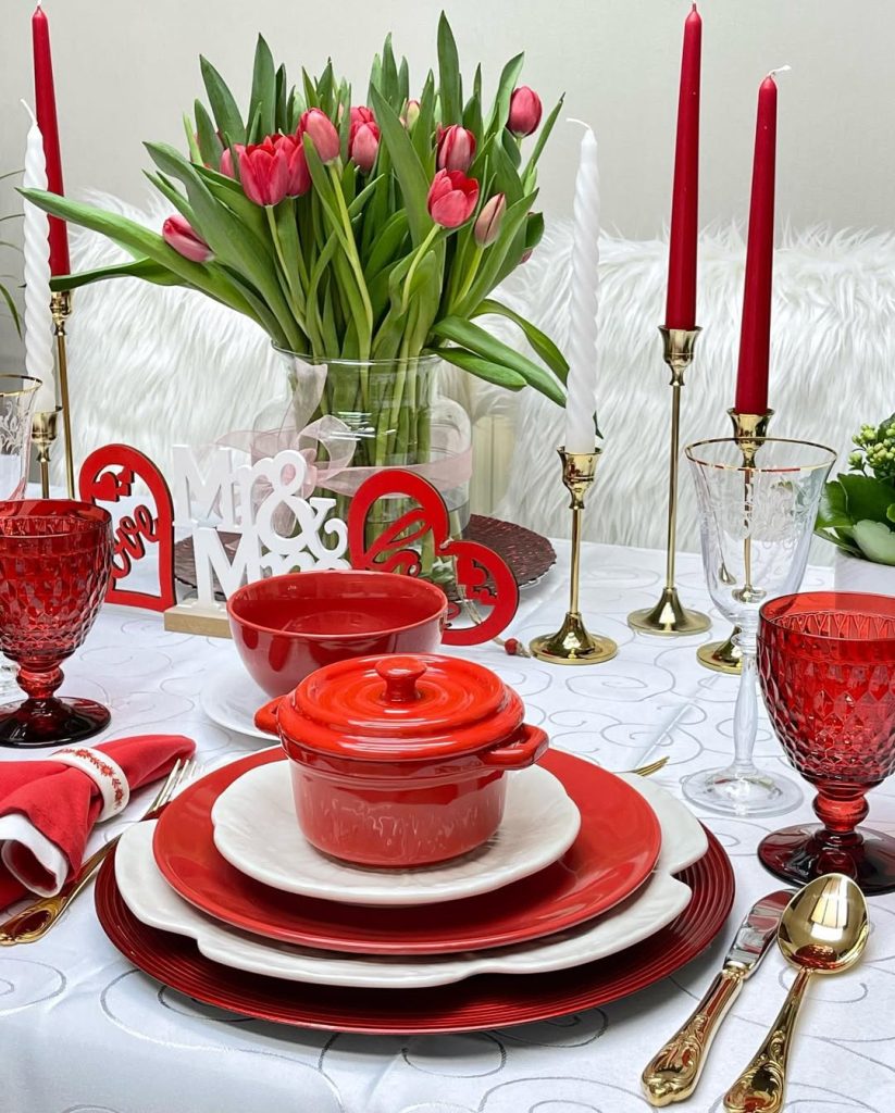 Bold red romantic table for two with gold accents and tulip centerpiece.
