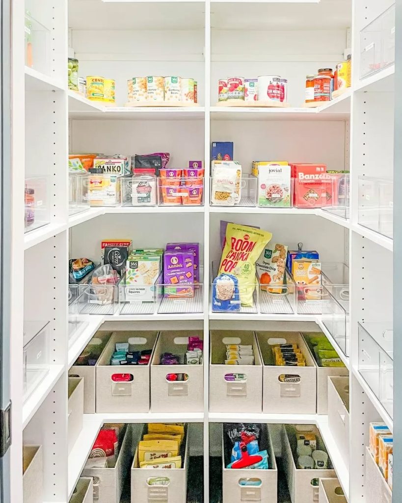 Color-coordinated pantry with bright white shelving and organized storage bins.
