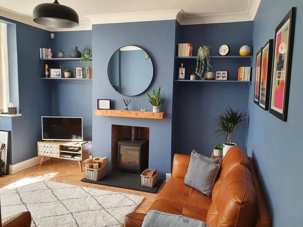 Rich navy walls with soft, cozy furniture for a sophisticated yet relaxed atmosphere