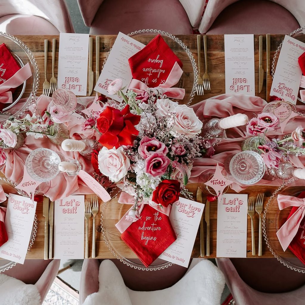 Elegant romantic table decoration with personalized menus and lush floral arrangements.






