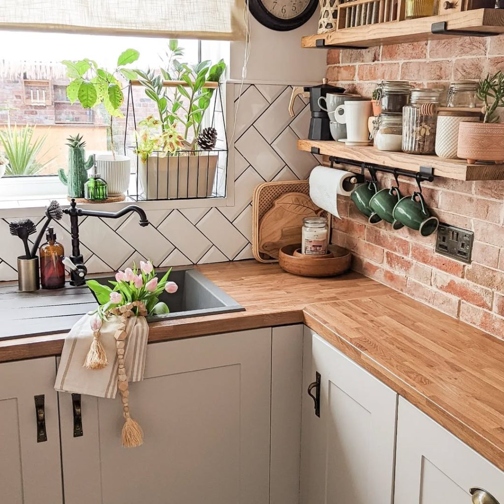 Minimalist boho kitchen with exposed brick and cozy decor.
