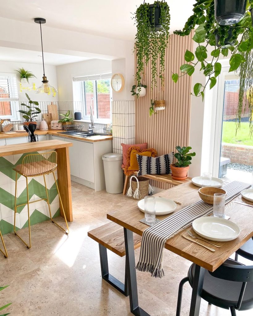 Modern boho kitchen with open shelving and greenery accents.
