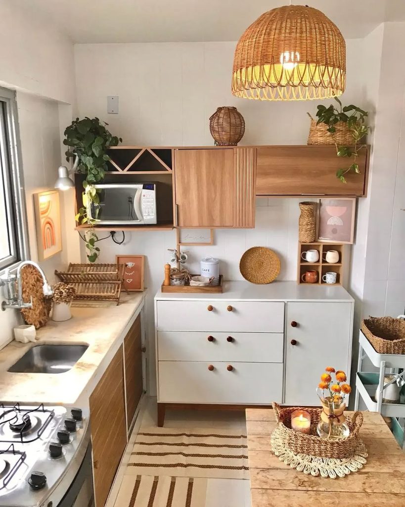 Small boho-style cozy kitchen with rattan pendant light, wood cabinets, and earthy tones.
