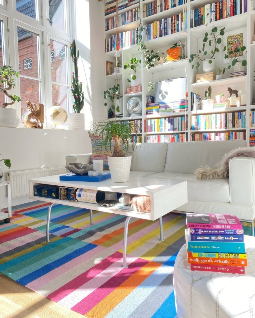 A vibrant living room featuring bookshelves filled with books and a stylish coffee table at the center.