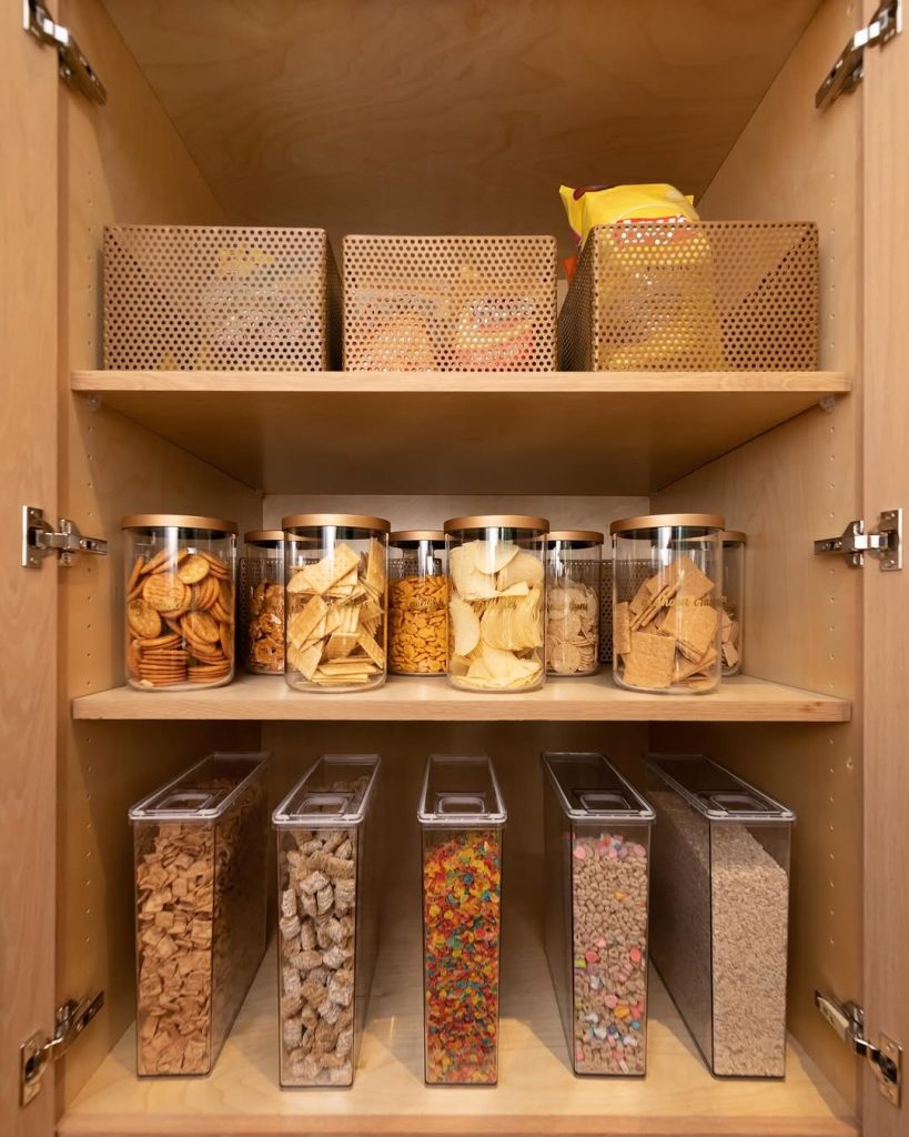 Snack pantry with clear storage containers for chips, crackers, and cereal.
