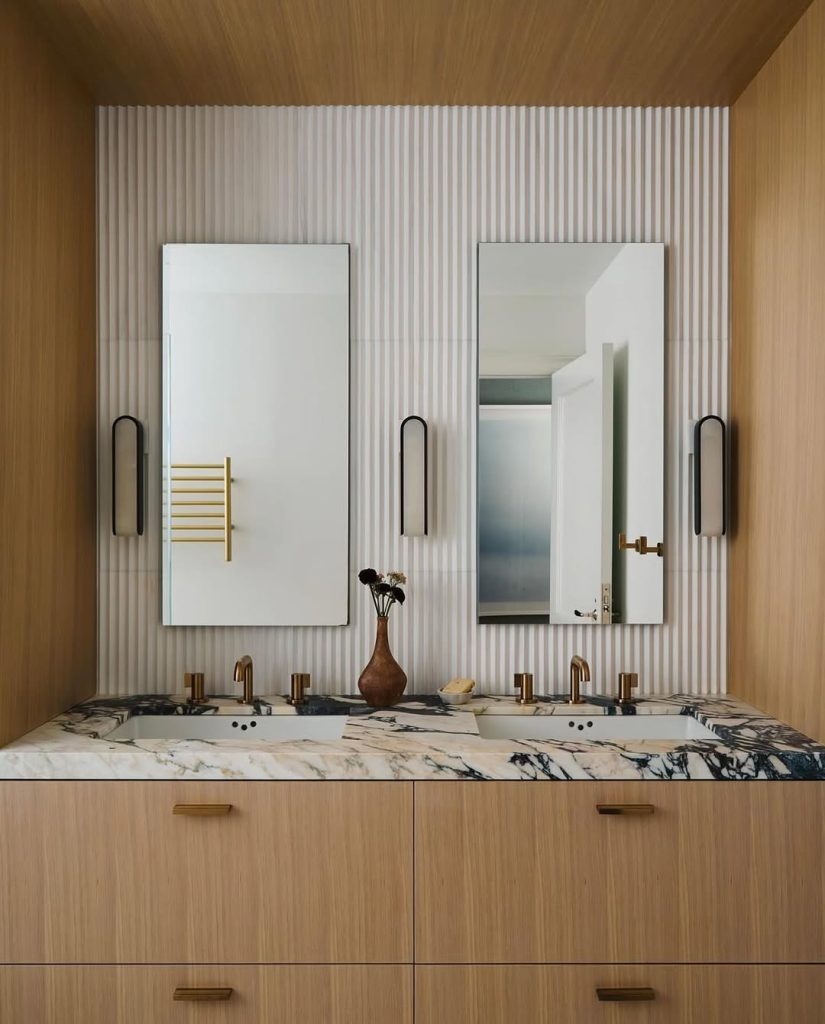 Warm wood and marble double vanity bathroom idea with gold accents.
