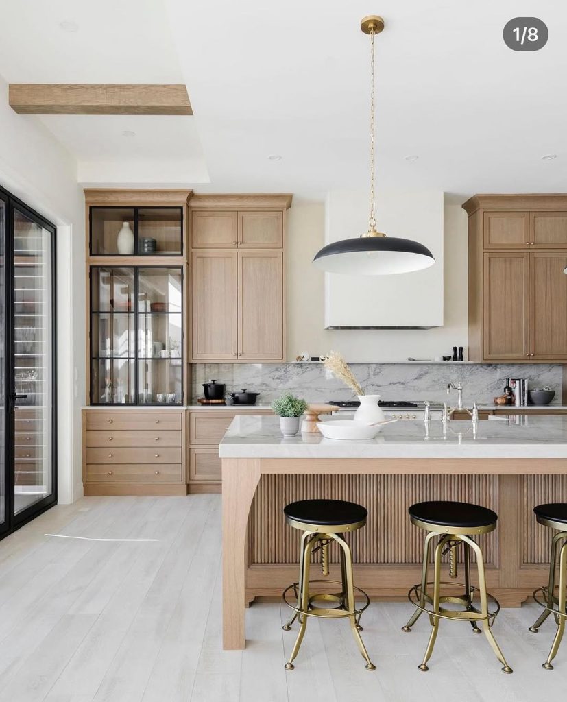 Warm oak kitchen cabinets with a stylish glass-front pantry and modern island
