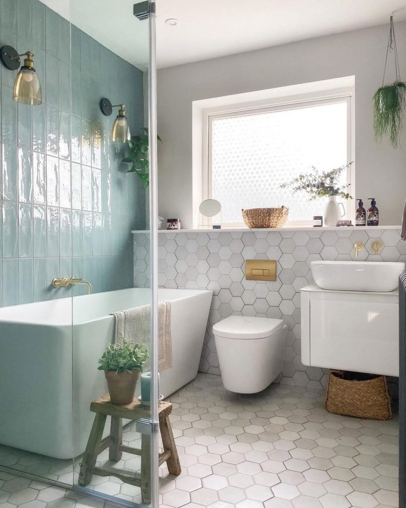 Sloped ceiling small bathroom with sage tiles and natural light.
