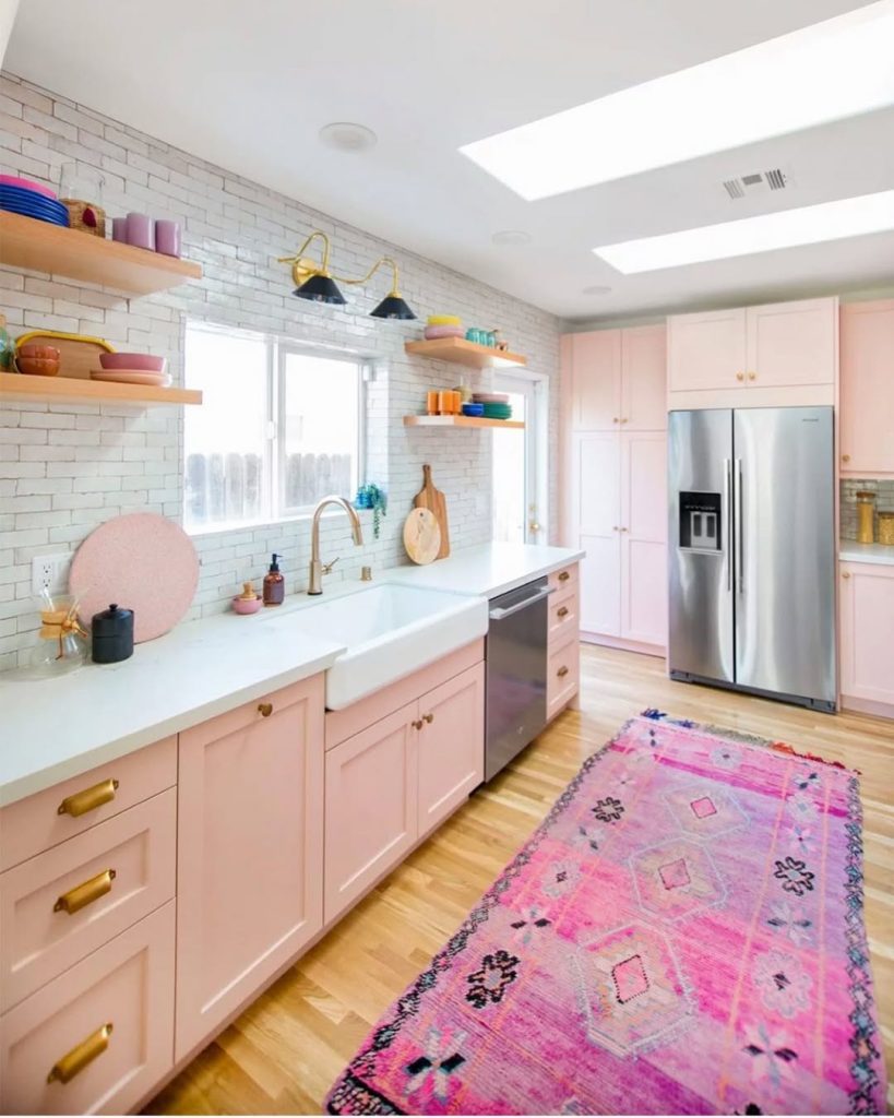 Playful pink kitchen cabinet ideas with brass handles and open shelving for storage
