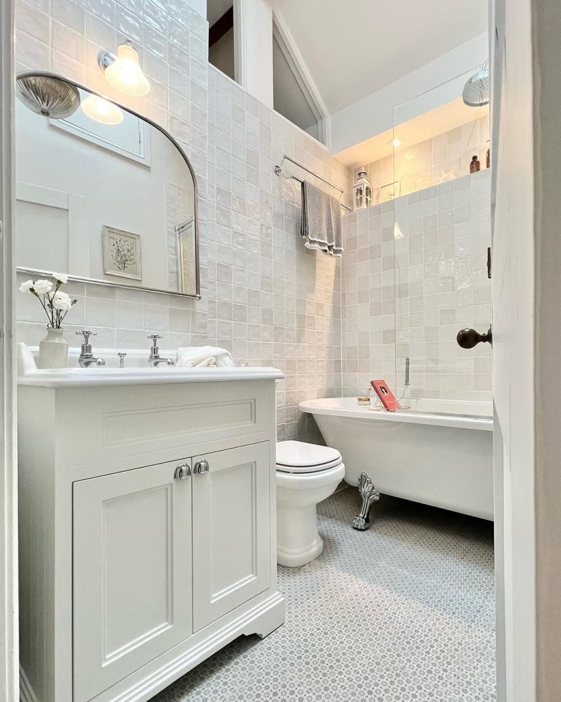 Luxurious neutral-toned small modern bathroom with marble and warm lighting.
