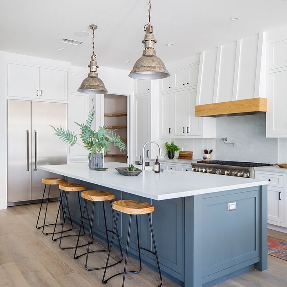 Classic white and navy kitchen cabinets with rustic wood range hood and pantry
