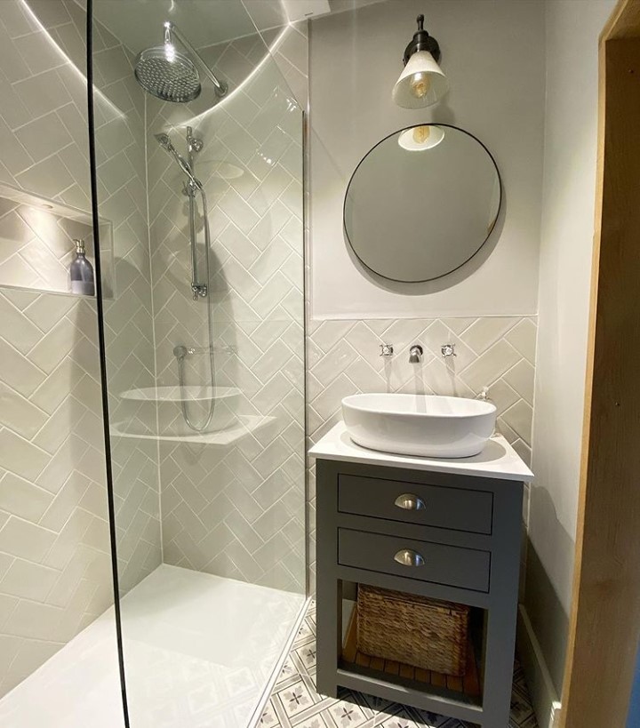 Monochrome small bathroom with subway tiles and green accent wall.
