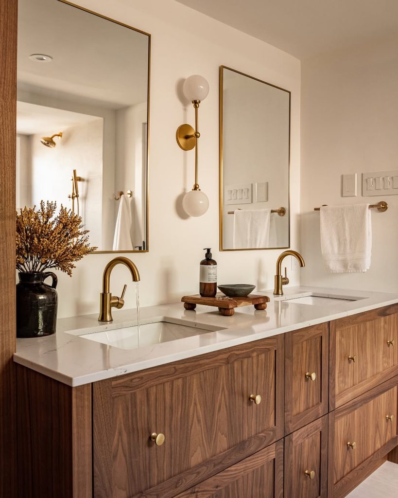 Classic and timeless gray double vanity with arched mirrors and vintage sconces.
