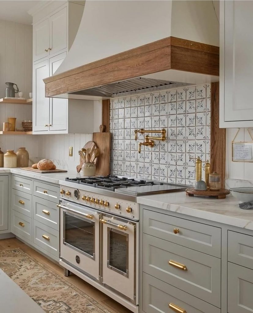 Vintage sage green kitchen cabinets with patterned backsplash and deep drawers
