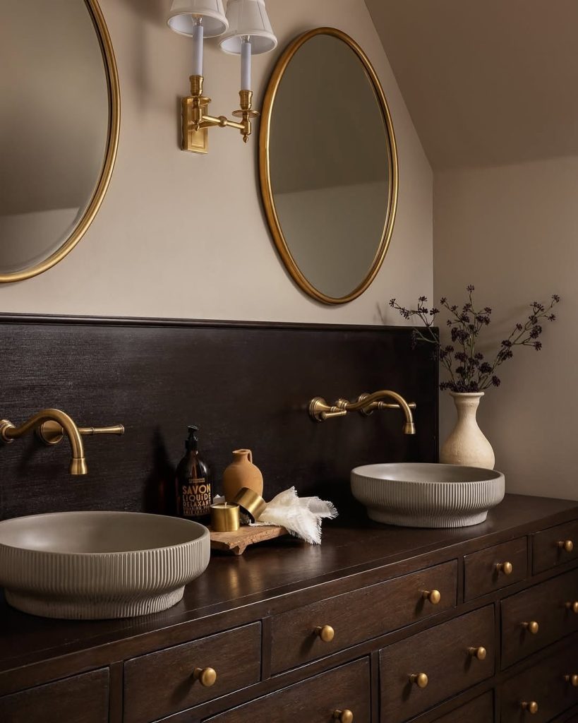 Vintage-inspired double vanity bathroom with vessel sinks and brass fixtures.
