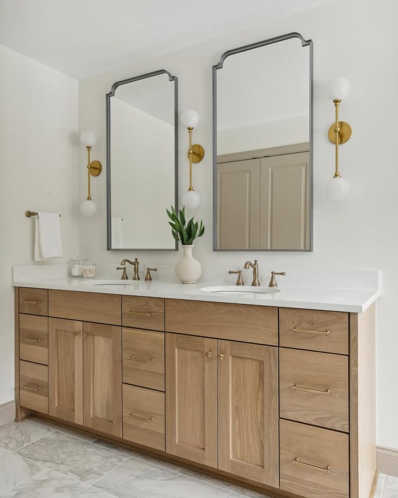 Classic double sink bathroom idea with light wood vanity and gold accents.
