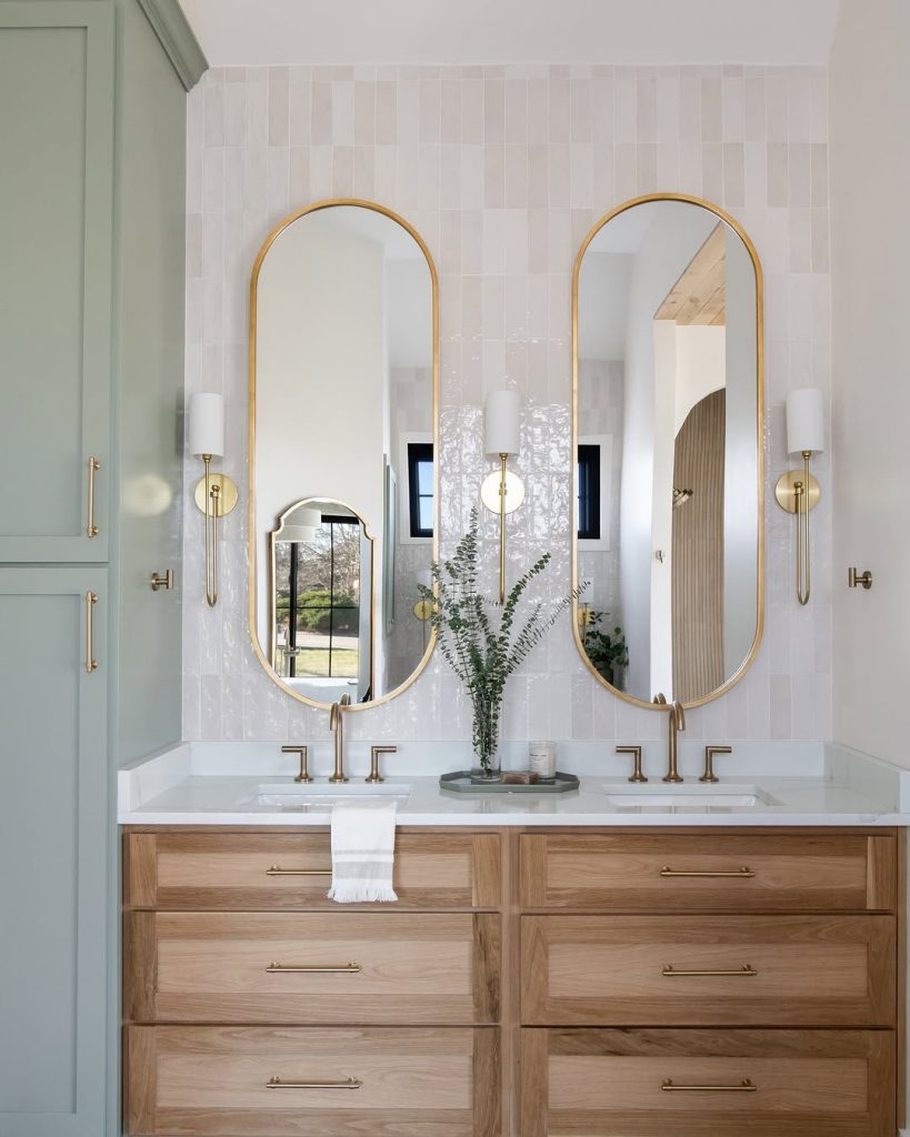 Soft green and wood double vanity bathroom idea with arched mirrors.
